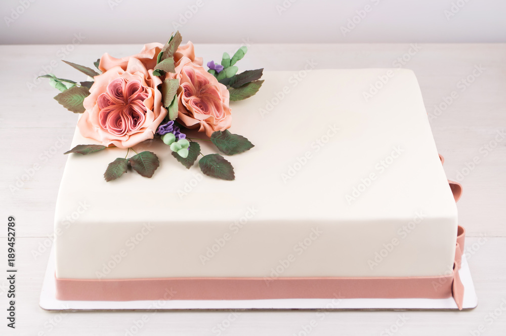 Rectangular art cake decorated with pink flowers and green leaves ...