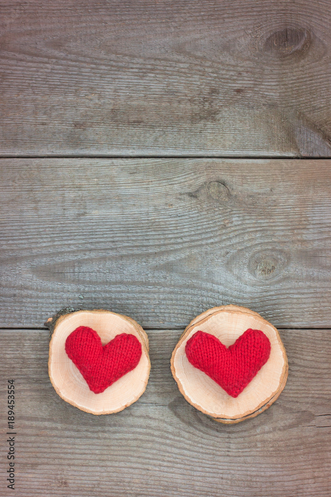 Two handmade red knitted hearts on the wooden background. Valentine's or Wedding's day postcard concept. Two handmade red knitted hearts on the wooden background. Valentine's or Wedding's day postcard concept.