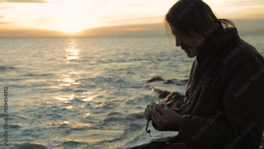 old man carving wood sculptures at seaside during sunset old man carving wood sculptures at seaside during sunset