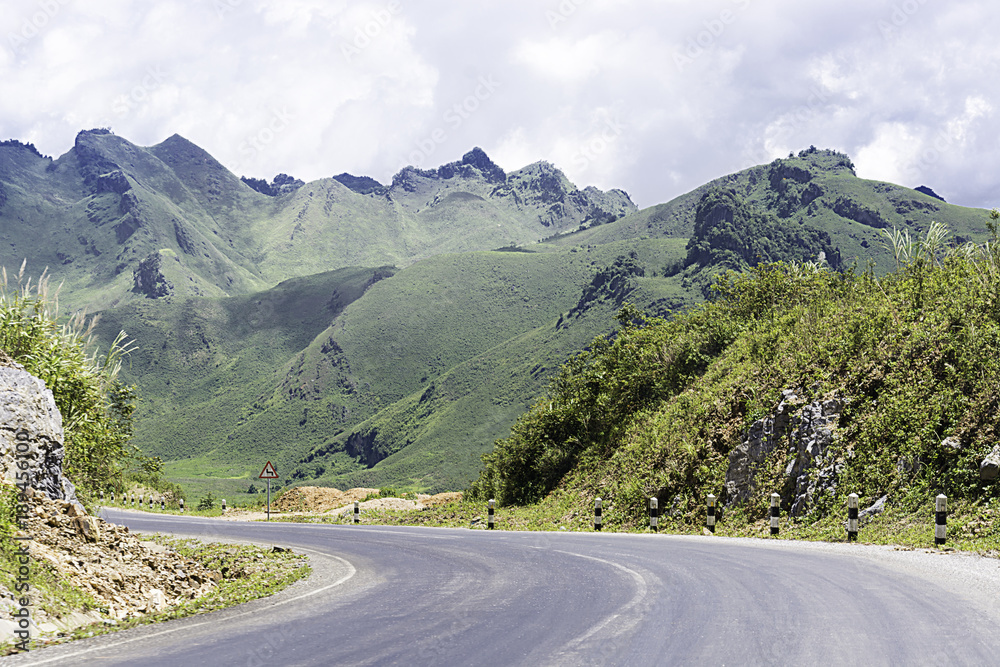 Naklejka premium Long And Winding Rural Roads Leading Through Green Hills In Laos, The Route Between Vang Vieng - Luang Prabang