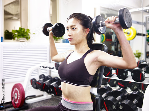 young asian woman exercising working out in gym