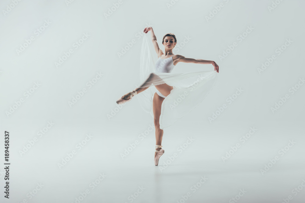 young elegant ballerina dancing in studio, isolated on white