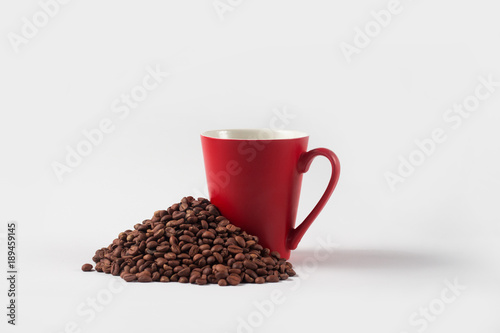 Beautiful image of a red cup with coffee and grains Coffee scattered around