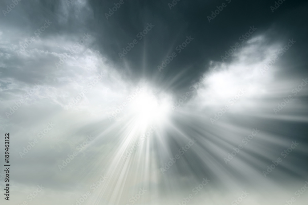 Rays of sun behind clouds of gray color
 