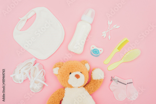 top view of teddy bear and baby equipment isolated on pink © LIGHTFIELD STUDIOS