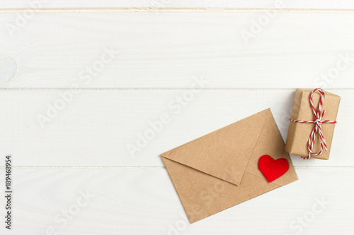 Valentine with red heart. A paper parcel wrapped tied. A red heart with gift box wrapped with paper kraft