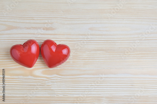 Two Red hearts on wooden background.
