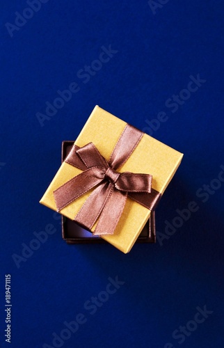 Open golden gift box on blue background