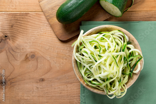 Raw zucchini noodles on a rustic background