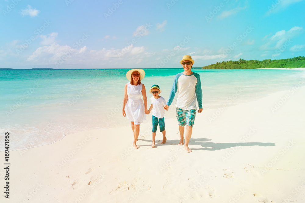 happy family with kid walking on beach