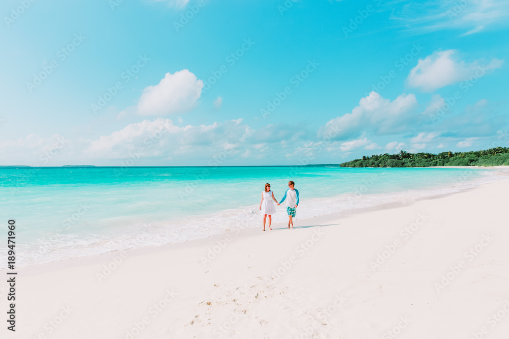 happy loving couple walking on beach