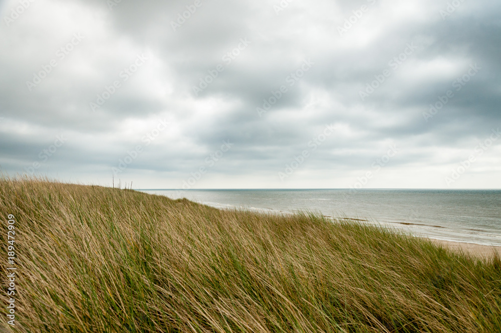 A grassy hill looking out over a cloudy sea in Northern France
