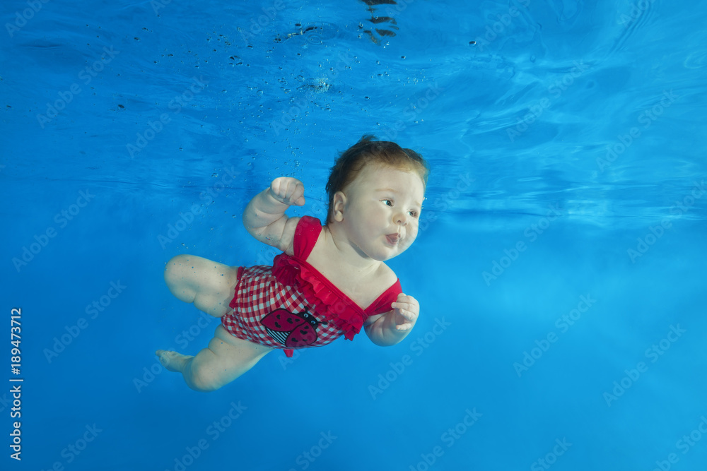 Naklejka premium little girl swim underwater in the pool