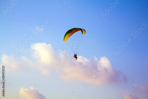 Paraglider flying over sea.Paraglider flies colorful paraglider in the blue sky.