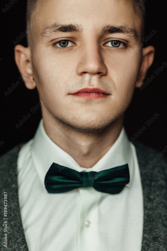 Handsome groom waiting for bride in luxury hotel room, morning before wedding ceremony, romantic groom in stylish suit posing indoors Handsome groom waiting for bride in luxury hotel room, morning before wedding ceremony, romantic groom in stylish suit posing indoors