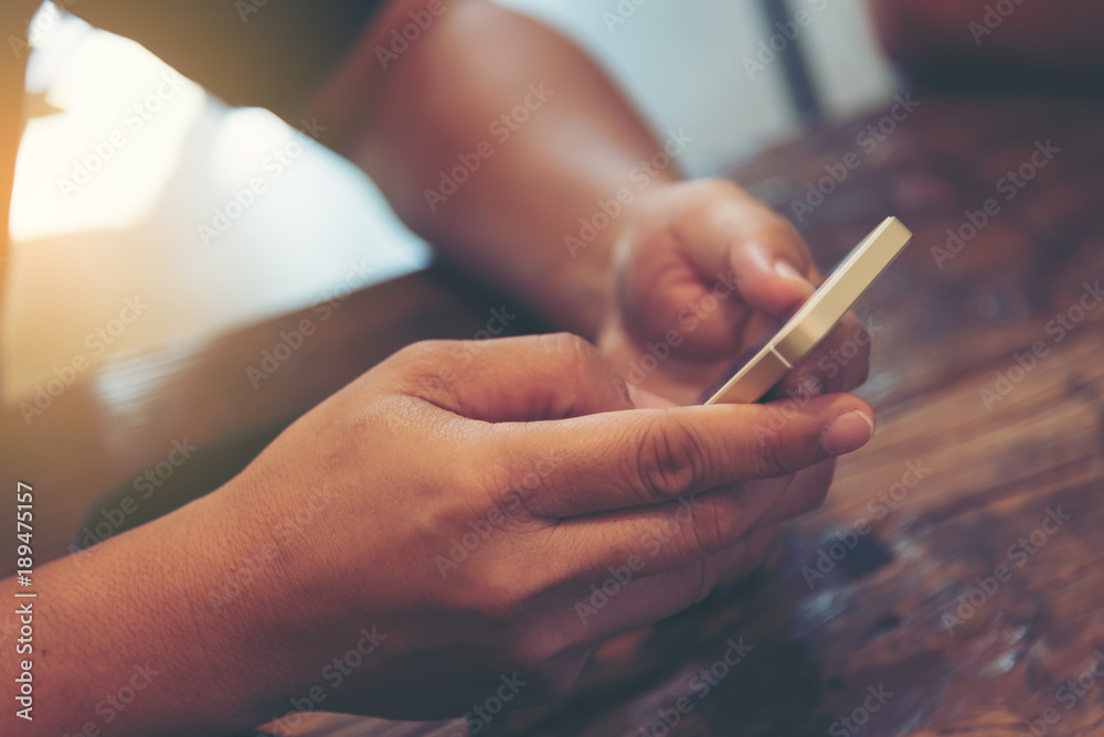 Selected focus on  man hand, relaxed using smart phone and digital tablet at coffee shop. Young man browsing on smart phone in interior building. E-business internet of things concept. Freelance.
