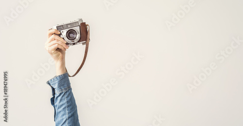 Raised up, arm holding vintage camera isolated background