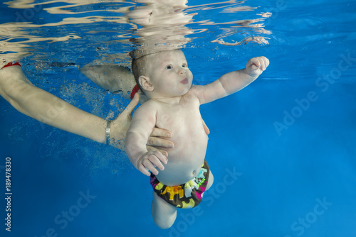 little 4 months boy learns to swim underwater in the pool © Andriy Nekrasov