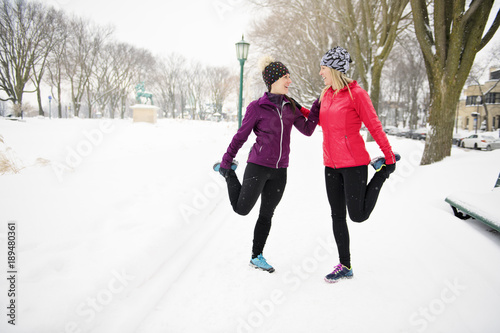 Group of friends enjoying jogging in the snow in winter