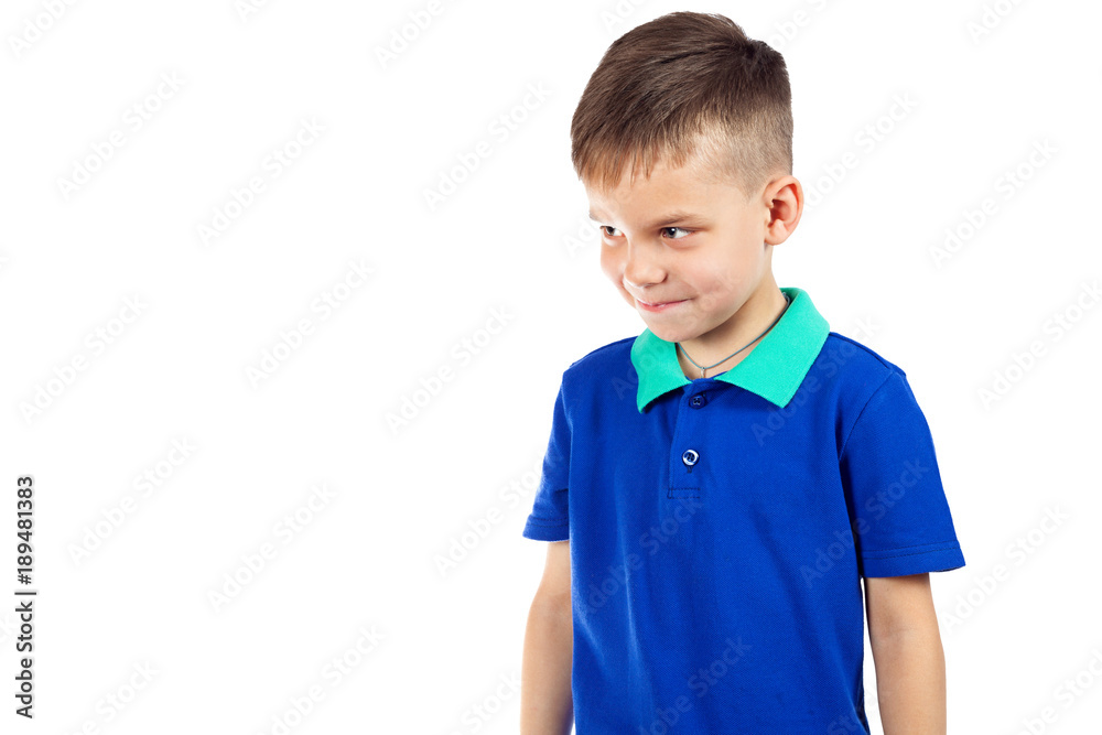 The little boy smiles slyly and looks away The little boy smiles slyly and looks away