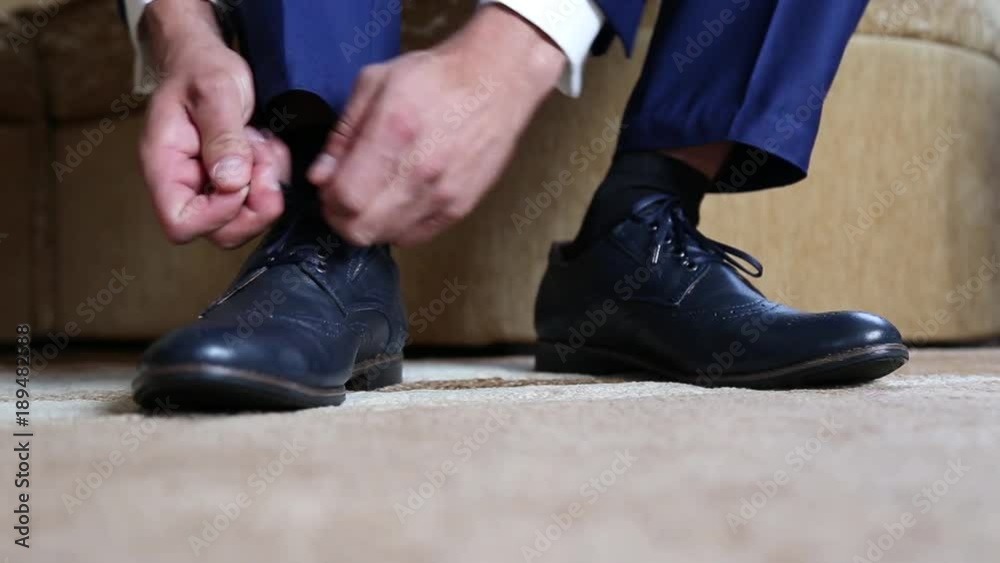 Business man dressing up with classic, elegant shoes. Groom wearing on wedding day, tying the laces and preparing.