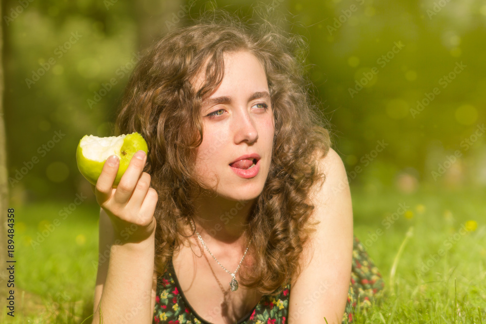 Young pretty woman eating apple on a field Young pretty woman eating apple on a field