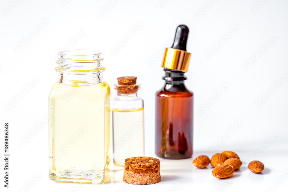 cosmetic almond oil in glass bottle on white background cosmetic almond oil in glass bottle on white background