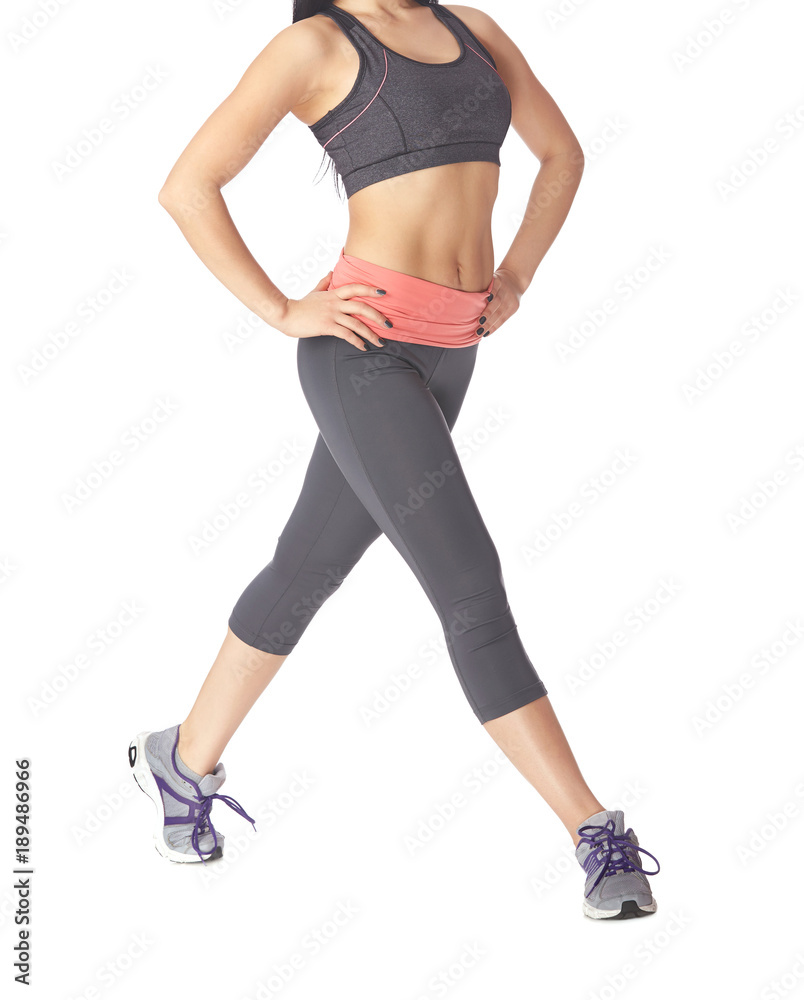Low section of sportive woman going on a white background