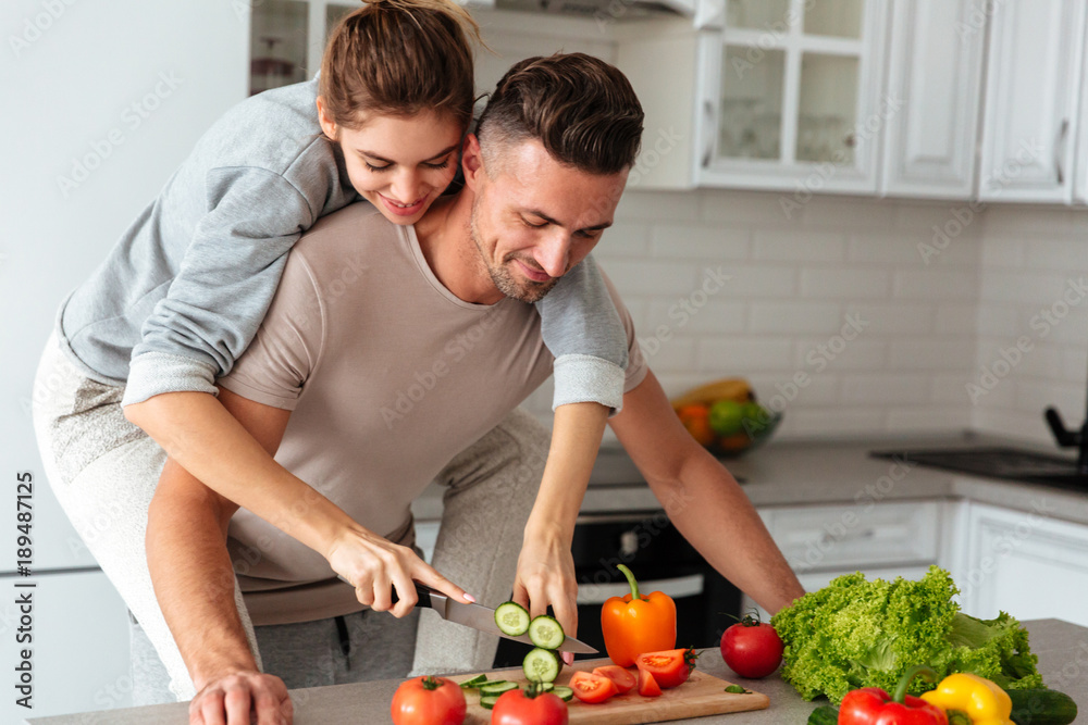 Portrait of a pretty loving couple cooking salad together Portrait of a pretty loving couple cooking salad together
