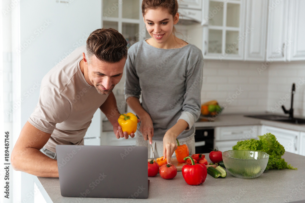 Portrait of a smiling loving couple cooking salad together Portrait of a smiling loving couple cooking salad together