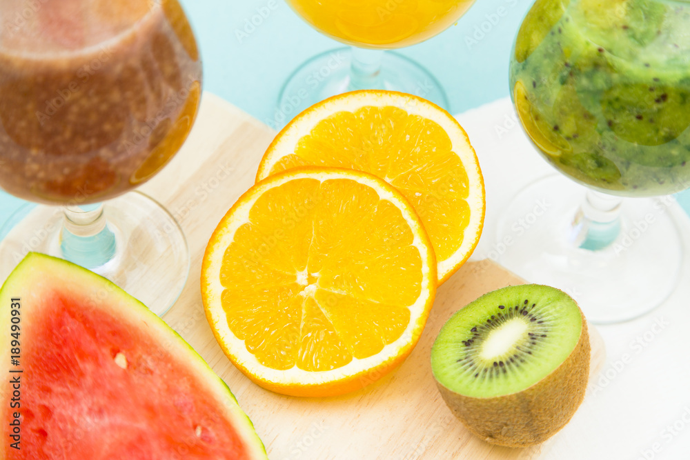 Tropical Smoothie Cocktail with fresh watermelon, orange, grapes and bananas. Light blue background, top viewHealthy food, Diet, Fitness, Dessert Concept Tropical Smoothie Cocktail with fresh watermelon, orange, grapes and bananas. Light blue background, top viewHealthy food, Diet, Fitness, Dessert Concept