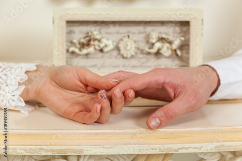 Bride and groom, wedding, two hands close-up against the background of angels. © Oleg