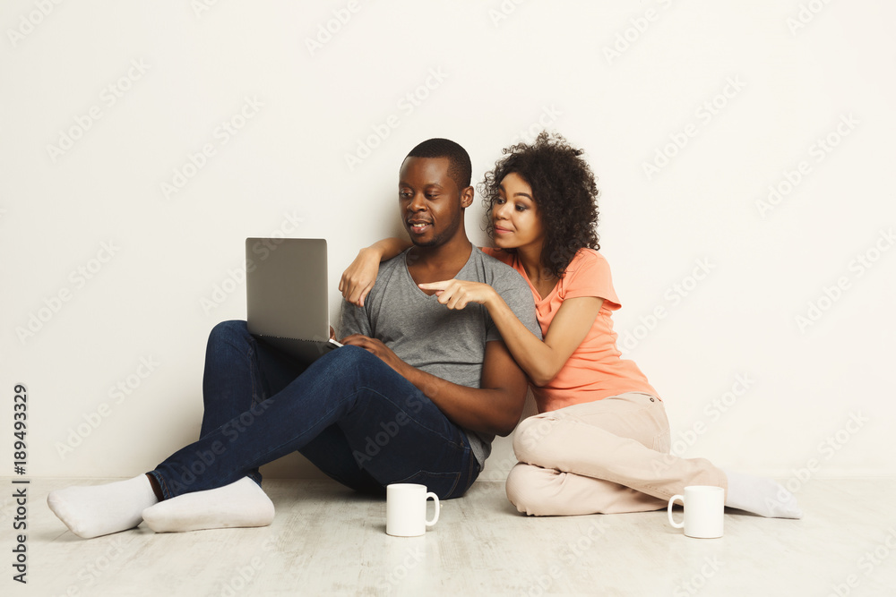 Happy african-american couple shopping online on laptop Happy african-american couple shopping online on laptop