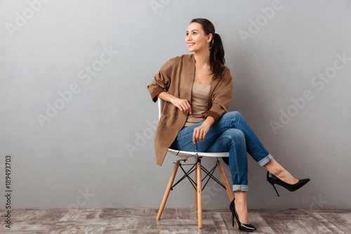 Portrait of a cheery asian woman sitting on a chair