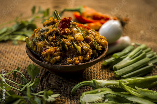 Close up of Indian Dish eaten in winter season Baingan ka Bharta with vegetables like:Spring onions,Allium fistulosum,Coriander,Coriandrum sativum,Garlic,Allium sativum and chills. photo