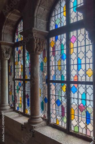Stained glass windows with bright colours decorating the interiors of an antique hall in the Château de la Napoule castle on a sunny summer day in Mandelieu-la-Napoule, Provence, France, Europe