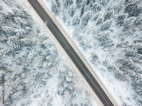 Road through the forest. Aerial view winter landscape