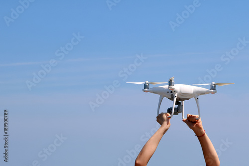 UAV or Drone camera fly up from the hands into the blue sky with ocean and island views on the mountain