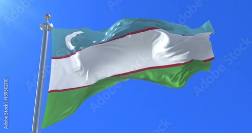 Flag of Uzbekistan waving at wind in slow with blue sky, loop photo