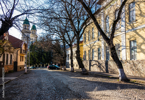 street of old town in sunny spring day. cobblestone road  beautiful architecture and old Cathedral in the distance