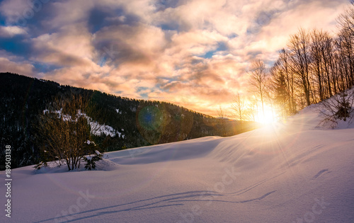sun rising behind the snowy slope. wonderful nature winter scenery in mountainous area © Pellinni