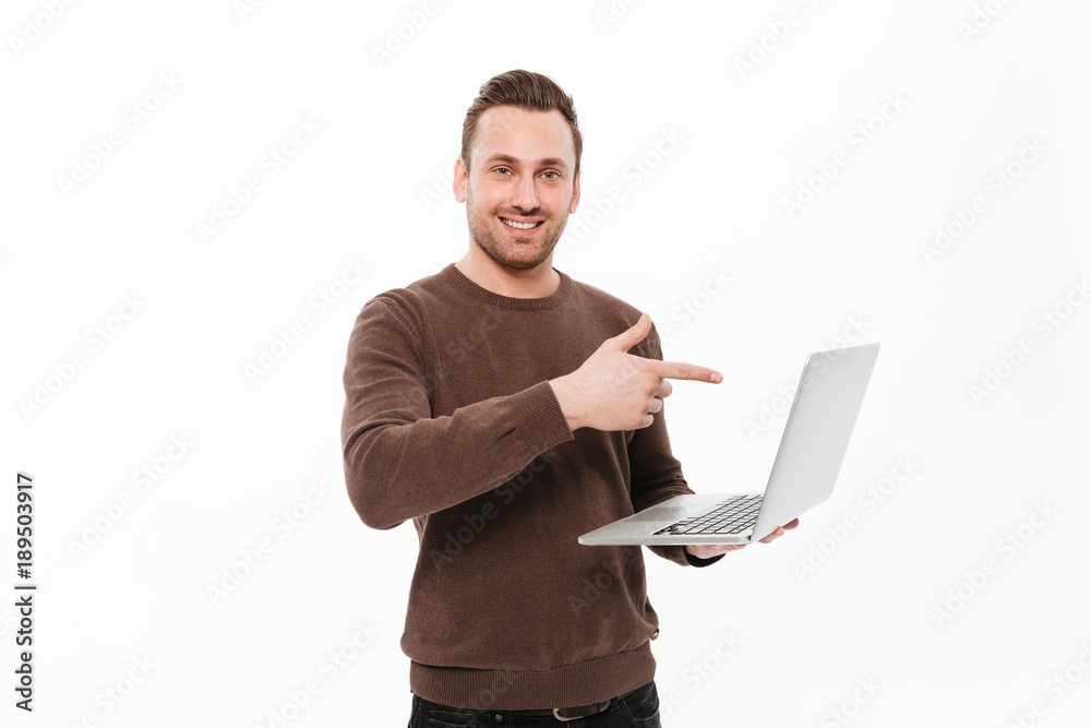 Smiling young man using laptop computer pointing. Smiling young man using laptop computer pointing.