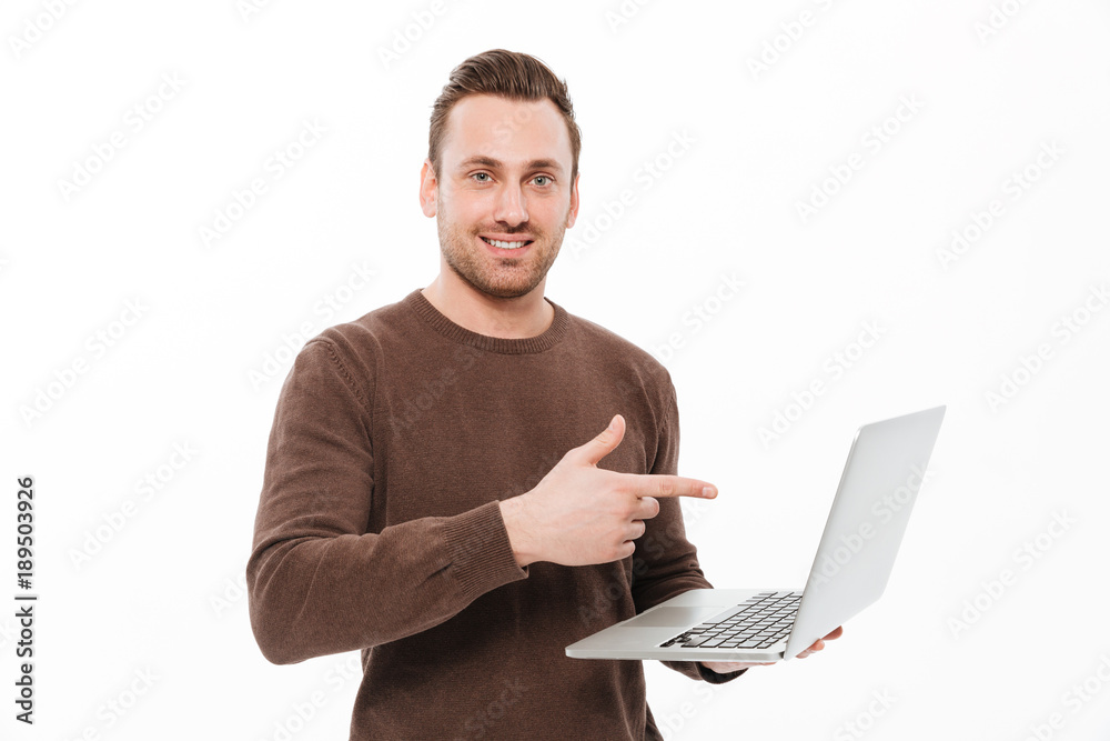 Smiling young man using laptop computer pointing. Smiling young man using laptop computer pointing.