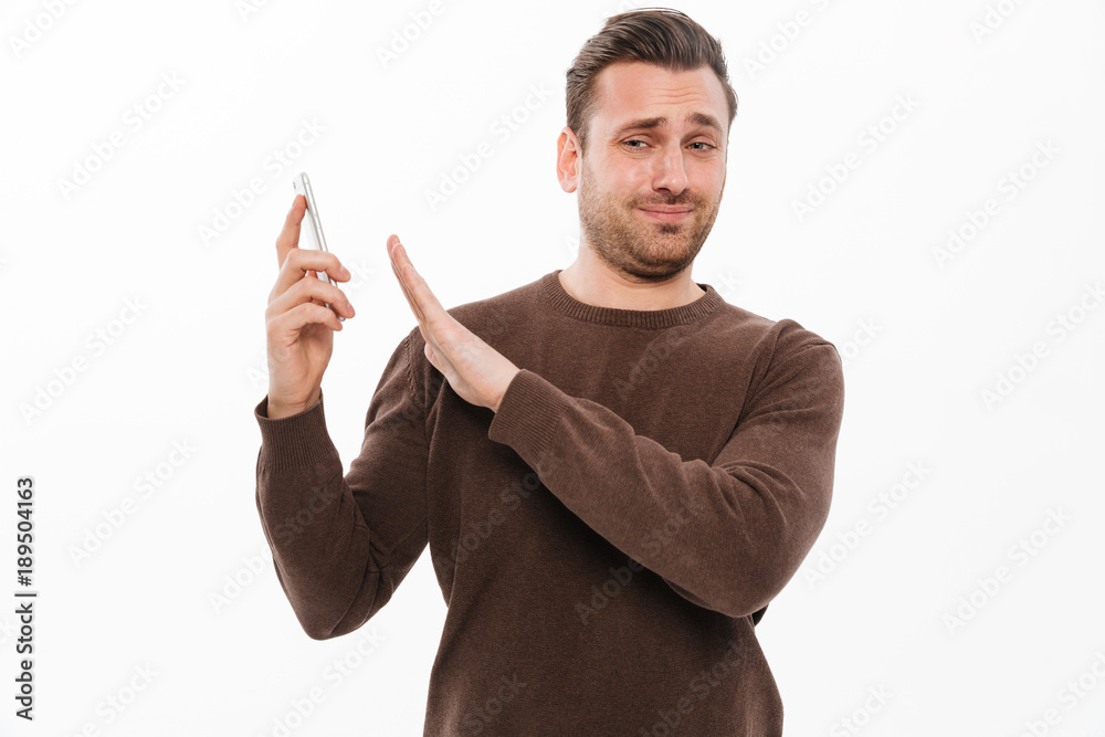 Confused young man talking by mobile phone Confused young man talking by mobile phone