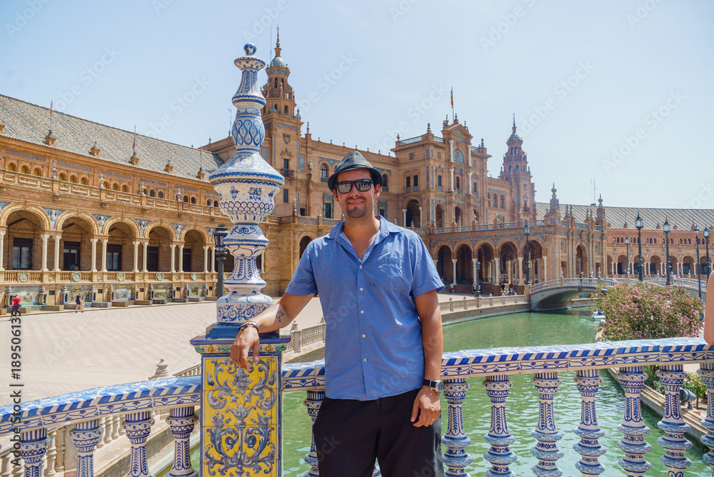 Fototapeta premium handsome happy couple take photo in Spain Square (Plaza de Espana), Seville, Spain, during a world trip tour