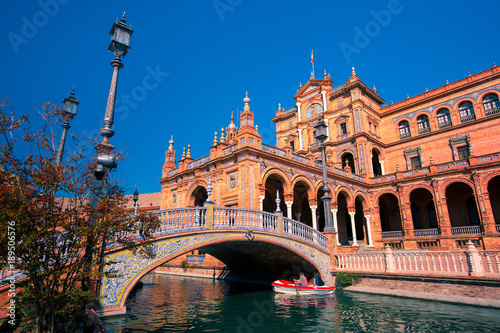 Spain Square or Plaza de Espana in Seville in the sunny summer day, Andalusia, Spain. Bridge, streetlight and channel in the foreground © Kavalenkava