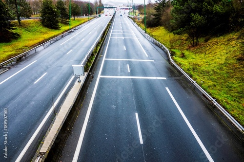 Automobile toll road is stretching to the horizon. Top view on an overcast day. Cash desks for payment of departure at the end of the road.