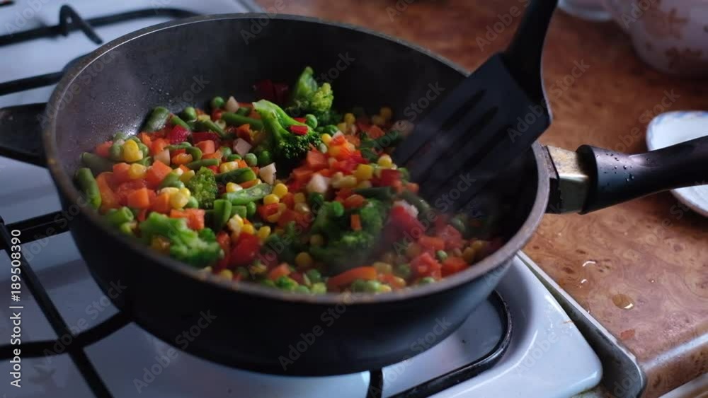 Frying and stirring the chopped vegetables in a pan Frying and stirring the chopped vegetables in a pan