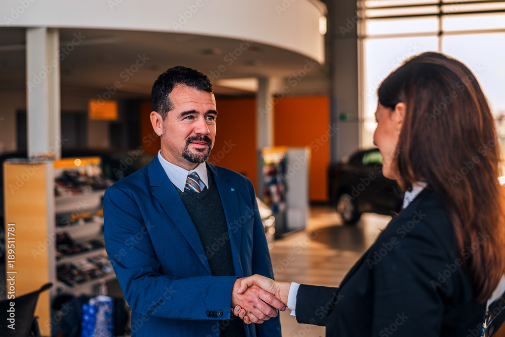 Mature businessman shaking hands with car dealer. Mature businessman shaking hands with car dealer.