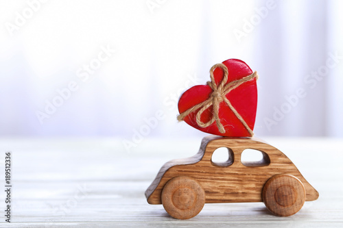 Decorative wooden car with heart figure on table